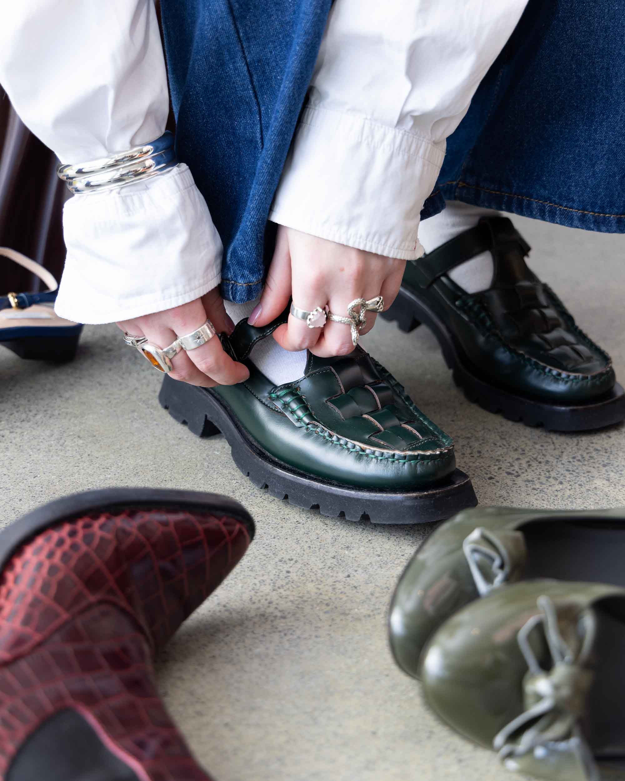 Person tries on a leather shoe. Image has a text overlay that reads '40 years of trusted designer consignment'.